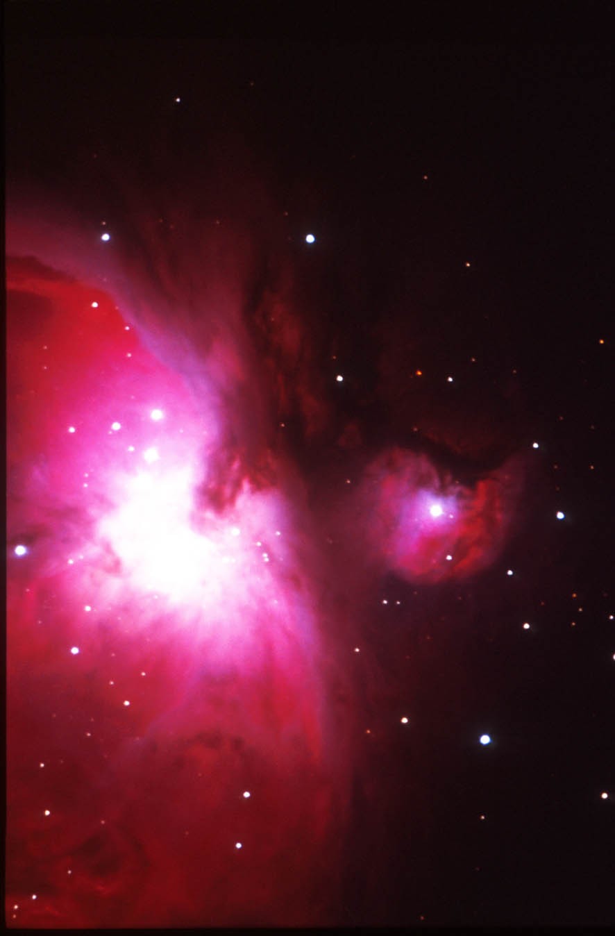 La Grande Nebulosa di Orione si trova nella spada dell'omonima costellazione. Si trova ad una distanza di circa 1500 anni luce, cioè la vediamo com'era e dov'era 1500 anni fa (oppure, se qualcuno potesse vederci a quella distanza, vedrebbe i risultati delle invasioni barbariche sulla nostra penisola). La nebulosa è formata da una distesa di diversi anni luce di gas, per lo più idrogeno, in gran parte meno denso di un buon vuoto di laboratorio. Dove questo gas si concentra, grazie all'attrazione gravitazionale, si formano le stelle. Al suo interno ce ne sono quasi un migliaio, quasi tutto giovanissime (qualche milione di anni d'età!). Sono proprio le radiazioni emesse da queste (in particolare quelle nell'ultravioletto) che "eccitano" il gas della nebulosa, che emette di conseguenza energia luminosa. (testo e foto P.Ochner)